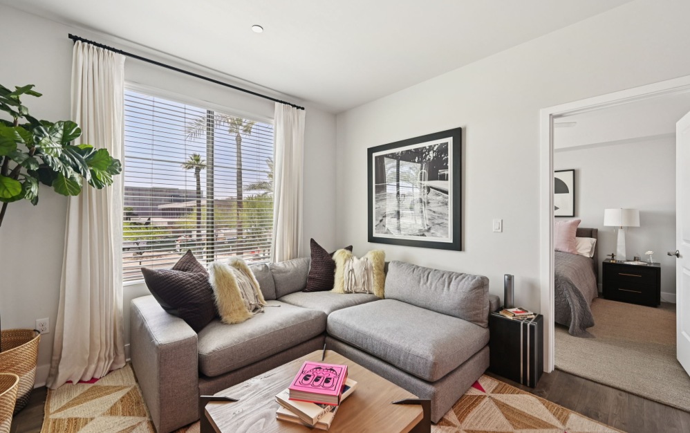 Furnished apartment living room with a large window at Arts District Apartments
