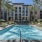 Arts District Apartments outdoor pool surrounded by lounge chairs and umbrellas