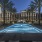 Arts District Apartments outdoor pool with under water lighting, surrounded by  lounge chairs and an entertainment area