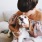 Lifestyle photo of woman sitting on a beige couch with her dog in her lap